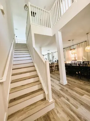 a white staircase in a house with a dining room at Enchanted Hideaway in Kissimmee