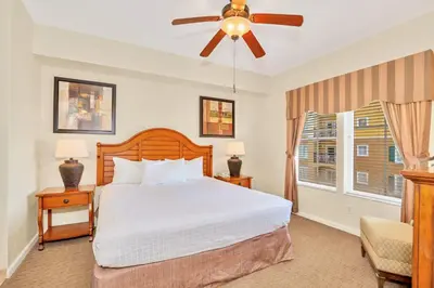 a bedroom with a bed and a ceiling fan at Cozy 2BR Condo Resort Spa with Pirate Pool in Kissimmee