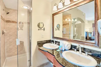 a bathroom with two sinks and a shower at Cozy 2BR Condo Resort Spa with Pirate Pool in Kissimmee