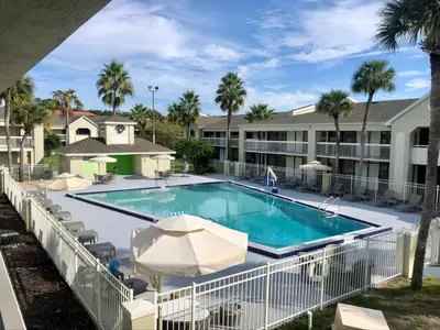 a swimming pool with umbrellas and a resort at Pool - WiFi - Parking - Best Location ! in Kissimmee