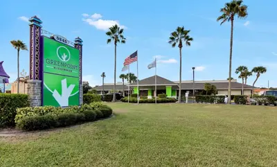 a sign in front of a building with palm trees at Pool - WiFi - Parking - Best Location ! in Kissimmee