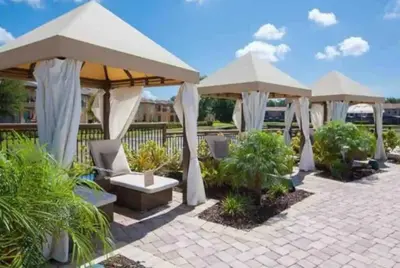 a patio with umbrellas and chairs and plants at Comfortable 3BdrmsPrivate Hot TubClose to Disney in Kissimmee