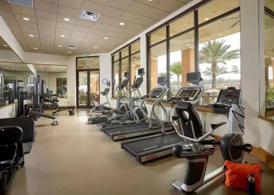 a gym with several treadmills and elliptical machines at Comfortable 3BdrmsPrivate Hot TubClose to Disney in Kissimmee