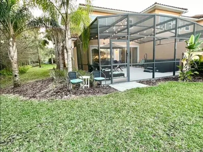 a glass house with two chairs and a table at Comfortable 3BdrmsPrivate Hot TubClose to Disney in Kissimmee