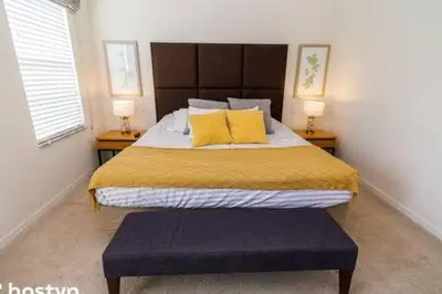 a bedroom with a large bed with yellow sheets and yellow pillows at Beautiful Townhome w Hot Tub Near Disney in Kissimmee