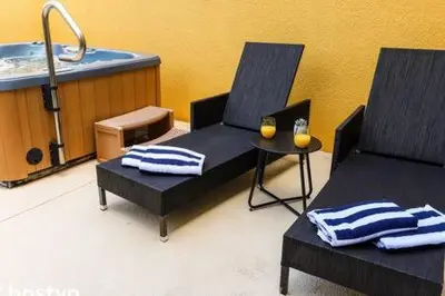 two chairs and a table in a bathroom with a tub at Beautiful Townhome w Hot Tub Near Disney in Kissimmee