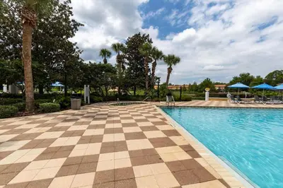 a swimming pool at a resort with palm trees at Beautiful Townhome w Hot Tub Near Disney in Kissimmee