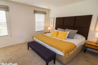 a bedroom with a large bed and two windows at Beautiful Townhome w Hot Tub Near Disney in Kissimmee