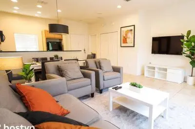 a living room with two couches and a table at Beautiful Townhome w Hot Tub Near Disney in Kissimmee