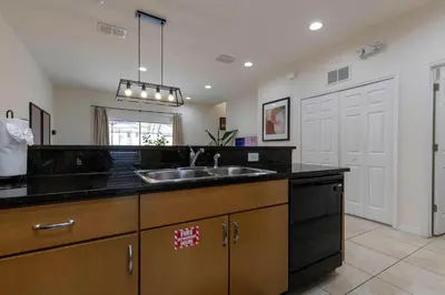 a kitchen with a sink and black counter top at Amazing Townhouse for 6 people near Disney in Kissimmee