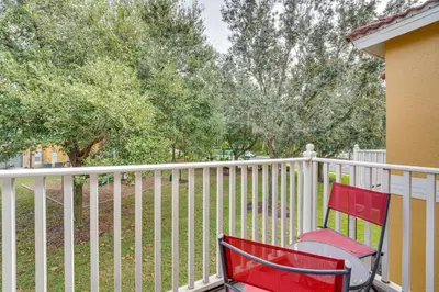 a red chair sitting next to a white fence at 4 Mi to Disney Emerald Island Resort Home! in Kissimmee