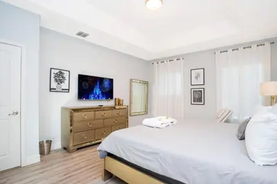 a bedroom with a bed and a dresser with a television at Last Minute Disney Getaway! Private Pool, Hot Tub & Games Room. Book Now! #60493 in Kissimmee