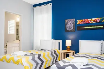a bedroom with two beds and a blue wall at Last Minute Disney Getaway! Private Pool, Hot Tub & Games Room. Book Now! #60493 in Kissimmee