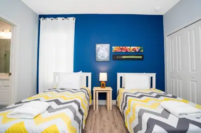 two beds in a room with blue walls at Last Minute Disney Getaway! Private Pool, Hot Tub & Games Room. Book Now! #60493 in Kissimmee