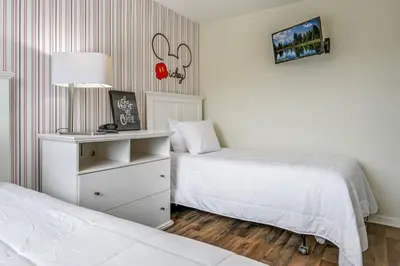 a bedroom with two beds and a dresser with a lamp at Top Villas - Bella Vida Resort 203 in Kissimmee