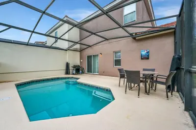 a swimming pool with a table and chairs and a table and a tablektop at Top Villas - Bella Vida Resort 203 in Kissimmee