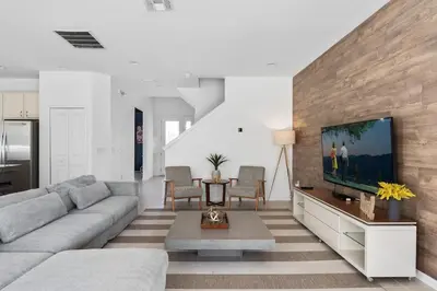 a living room with a couch and a flat screen tv at Last Minute Disney Private Pool Hot Tub Game Room Themed Bedrooms. Book Now 43123 in Kissimmee