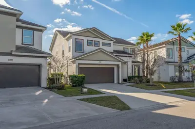 a large white house with a garage at Last Minute Disney Private Pool Hot Tub Game Room Themed Bedrooms. Book Now 43123 in Kissimmee