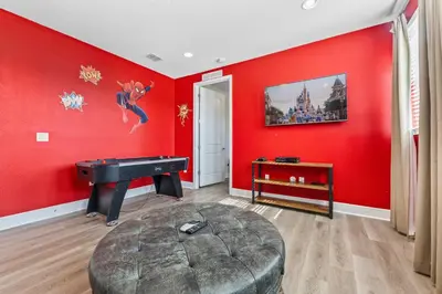 a living room with red walls and a pool table at Last Minute Disney Getaway! Private Pool, Hot Tub & Games Room. Book Now! #39430 in Orlando