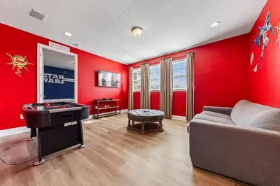 a red room with a couch and a video game at Last Minute Disney Getaway! Private Pool, Hot Tub & Games Room. Book Now! #39430 in Orlando