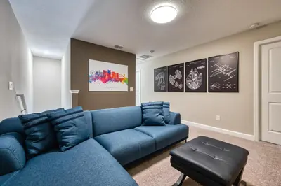 a living room with a blue couch in a room at Last Minute Disney Getaway Private Pool Themed Bedrooms. Book Now 81931 in Orlando