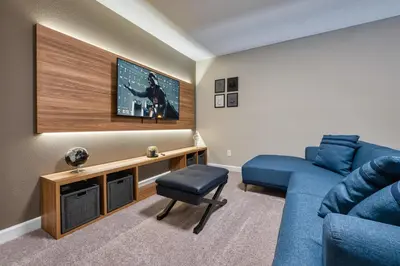 a living room with a blue couch and a tv at Last Minute Disney Getaway Private Pool Themed Bedrooms. Book Now 81931 in Orlando