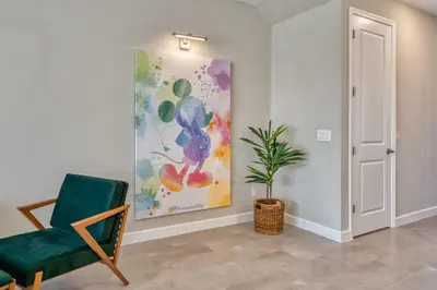 a room with a chair and a painting on the wall at Last Minute Disney Getaway Private Pool Themed Bedrooms. Book Now 81929 in Orlando