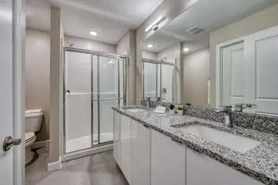 a bathroom with two sinks and a shower at Last Minute Disney Getaway Private Pool Themed Bedrooms. Book Now 81929 in Orlando