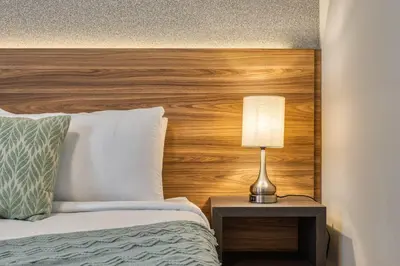 a bed with a wooden headboard and a lamp on a table at Last Minute Disney Getaway Private Pool Themed Bedrooms. Book Now 81925 in Orlando