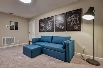 a living room with a blue couch and a lamp at Last Minute Disney Getaway Private Pool Themed Bedrooms. Book Now 81953 in Orlando