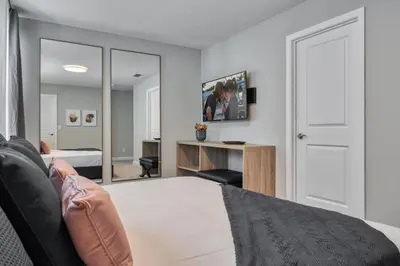 a bedroom with a bed and a desk and a mirror at Last Minute Disney Getaway Private Pool Themed Bedrooms. Book Now 81911 in Orlando