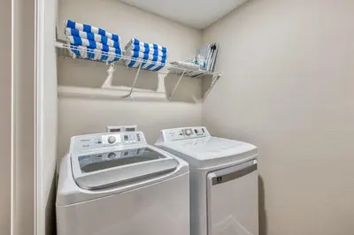 a small laundry room with a washer and dryer at Last Minute Disney Getaway Private Pool Themed Bedrooms. Book Now 81901 in Orlando