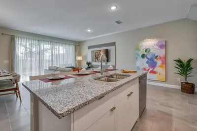 a kitchen with a sink and a living room at Last Minute Disney Getaway Private Pool Themed Bedrooms. Book Now 81899 in Orlando