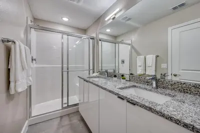 a white bathroom with two sinks and a shower at Last Minute Disney Getaway Private Pool Themed Bedrooms. Book Now 81895 in Orlando