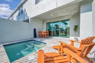 a swimming pool with two chairs and a table at Last Minute Disney Getaway Private Pool Themed Bedrooms. Book Now 81945 in Orlando