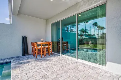 a patio with a table and chairs next to a pool at Last Minute Disney Getaway Private Pool Themed Bedrooms. Book Now 95041 in Orlando