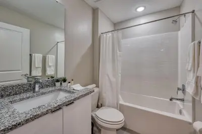 a white bathroom with a toilet and a sink at Last Minute Disney Getaway Private Pool Themed Bedrooms. Book Now 95041 in Orlando