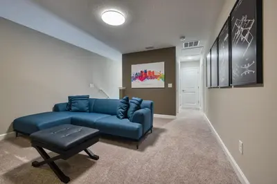 a living room with a blue couch and a stool at Last Minute Disney Getaway Private Pool Themed Bedrooms. Book Now 92789 in Orlando