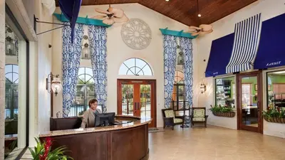 a man sitting at a bar in a lobby at Last Minute Disney Getaway! Private Pool, Hot Tub & Games Room. Book Now! #56201 in Kissimmee