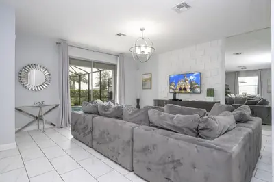 a large living room with a large gray couch at Last Minute Disney Private Pool Hot Tub Themed Bedrooms. Book Now 93745 in Kissimmee