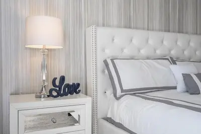 a bedroom with a white bed and a lamp on a night stand at Last Minute Disney Private Pool Hot Tub Themed Bedrooms. Book Now 93745 in Kissimmee