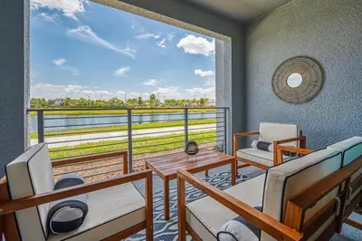 a room with a balcony with a table and chairs at Storey Lake Resort 1081 - Hosted by Top Villas in Kissimmee