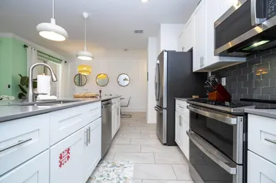 a kitchen with white cabinets and a black refrigerator at Storey Lake Resort 1082 - Hosted by Top Villas in Kissimmee