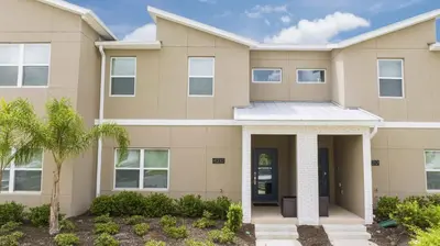 a house with a palm tree in front of it at Storey Lake Resort 1082 - Hosted by Top Villas in Kissimmee