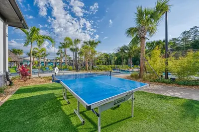 a ping pong table in a yard with palm trees at Storey Lake Resort 1082 - Hosted by Top Villas in Kissimmee