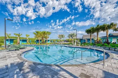 a swimming pool with benches and palm trees at Storey Lake Resort 1083 - Hosted by Top Villas in Kissimmee