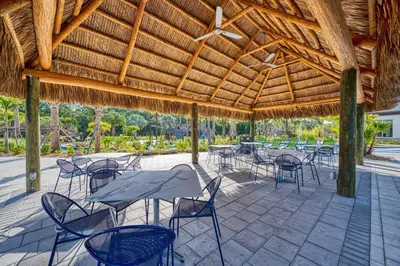 a patio with tables and chairs under a wooden roof at Storey Lake Resort 1083 - Hosted by Top Villas in Kissimmee