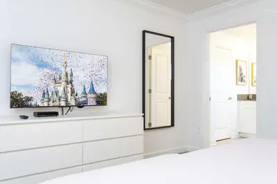 a white living room with a tv on a wall at Storey Lake Resort 1084 - Hosted by Top Villas in Kissimmee