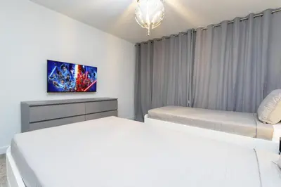 a bedroom with two beds and a tv on the wall at Storey Lake Resort 1084 - Hosted by Top Villas in Kissimmee