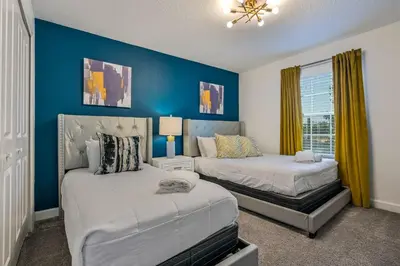 a bedroom with two beds and a blue wall at Storey Lake Resort 1085 - Hosted by Top Villas in Kissimmee